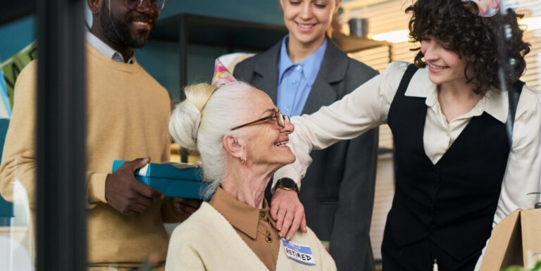Elderly Woman Smiling With Facility Staff During Celebration in Assisted Living