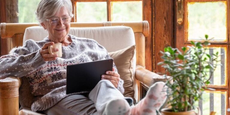 Elderly Woman Relaxing with Tablet and Coffee at Assisted Living Facility