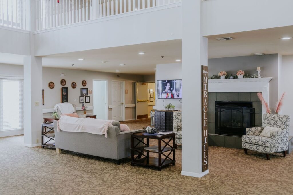 Warm Common Living Area With Fireplace And Comfortable Seating At Assisted Living Facility