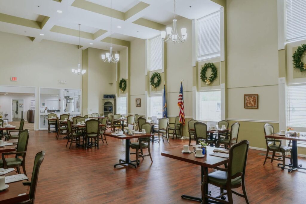 Grand Dining Room With Soaring Ceilings And Elegant Chandeliers At Assisted Living Facility